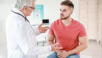 Un medico atende a un paciente jóven con síntoma de prostatitis