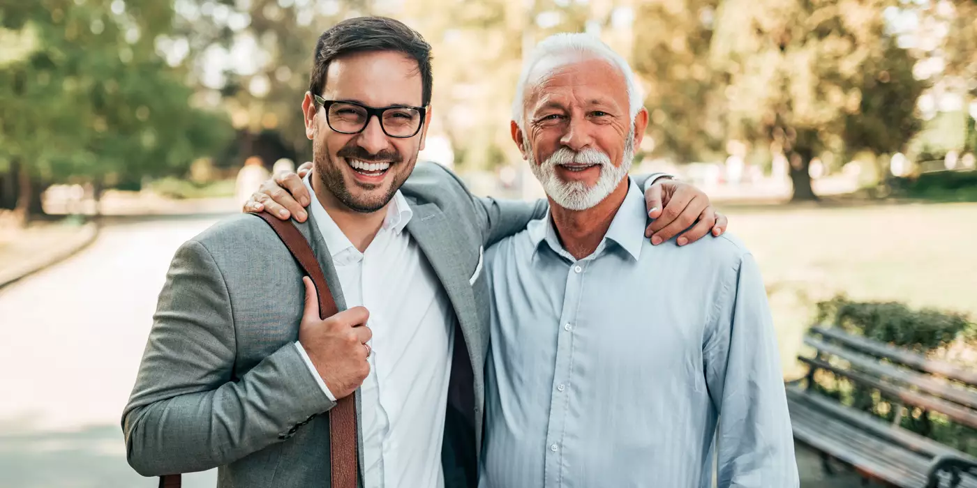 Padre e hijo adulto se abrazan afectivamente